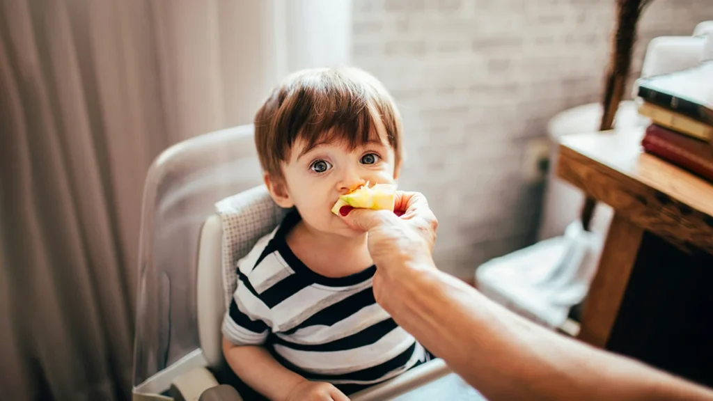 The baby is eating breakfast filled with nutrition